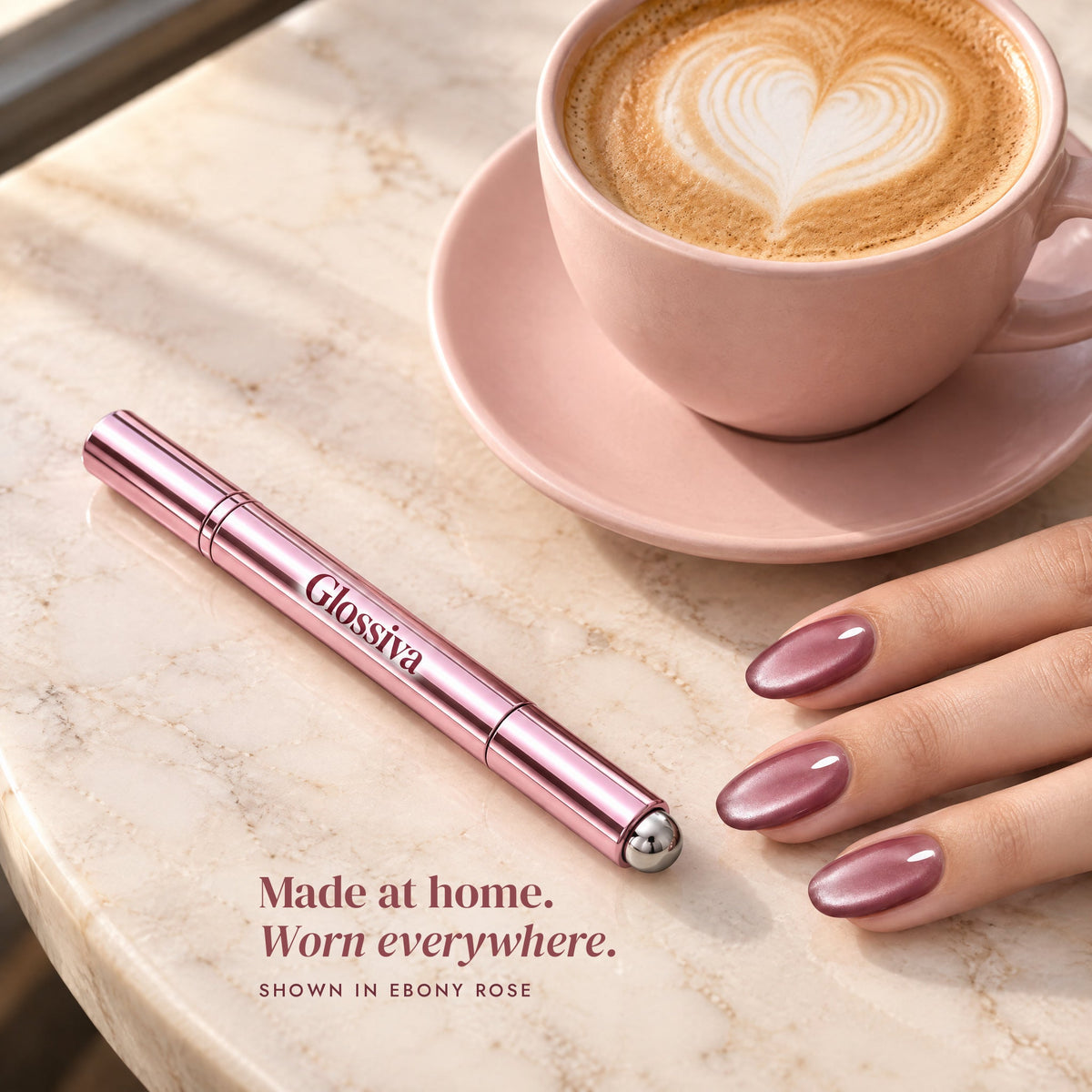 Glossiva cat-eye nails in Ebony Rose next to a latte and the gel pen